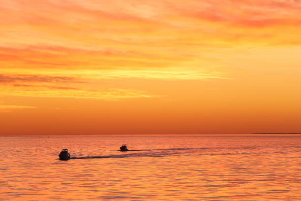 Fishing boats sailing glassy waters