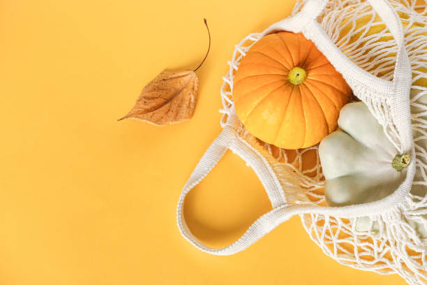 fruits de légumes frais citrouille, courge pattypan dans le sac de maille écologique shopping, feuilles d'automne sur fond jaune. concept récolte de légumes biologiques. top view flat lay template - pattypan squash photos et images de collection