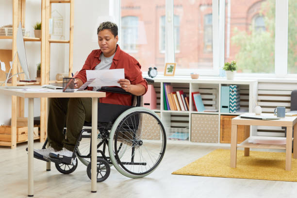 donna disabile che lavora sul posto di lavoro - working physical impairment people occupation foto e immagini stock