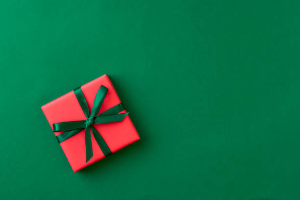 istock Red gift box on green background. Christmas card. Flat lay. Top view with space for text 1178271649