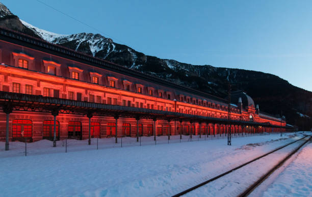 istock Old Canfranc train station with the facade illuminated in reddish tones on a winter night with snow on the tracks, Huesca,Spain 1178275055