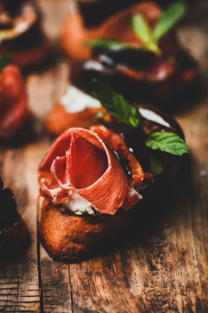 istock Crostini with prosciutto, goat cheese and figs on wooden board 1178275537
