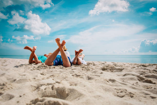 padre con figlio e figlia rilassarsi sulla spiaggia - american pastime foto e immagini stock