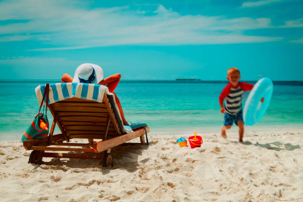 istock mother relax while child enjoy playing at beach vacation 1178278944