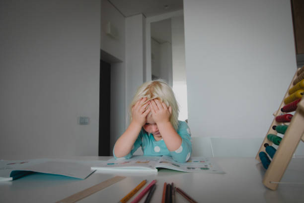 istock little girl tired and stressed of learning, doing homework 1178279307