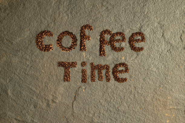 Word coffee made from coffee beans. A word from coffee roasted grains on a white background. Roasted coffee beans in shape of alphabets, coffee. Brown coffee beans isolated on white board. Copy-space.