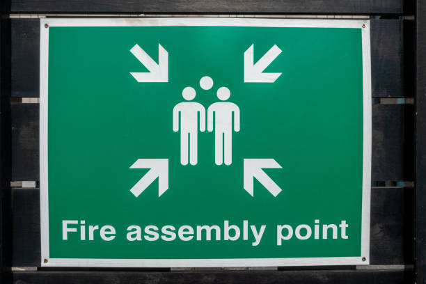 istock Fire Assembly Point sign on a black painted wooden fence 1178286465