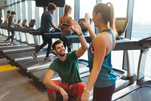 Sporty couple giving high five to each other at gym