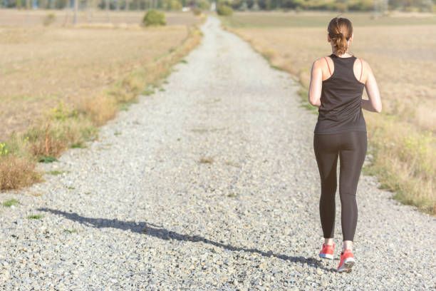 istock Woman trains her endurance while running on a dirt road 1178291710