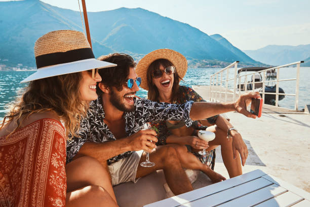 group of friends spending fun time by the sea friends spending fun time by the sea drinking cocktails and making selfies yacht selfie stock pictures, royalty-free photos & images