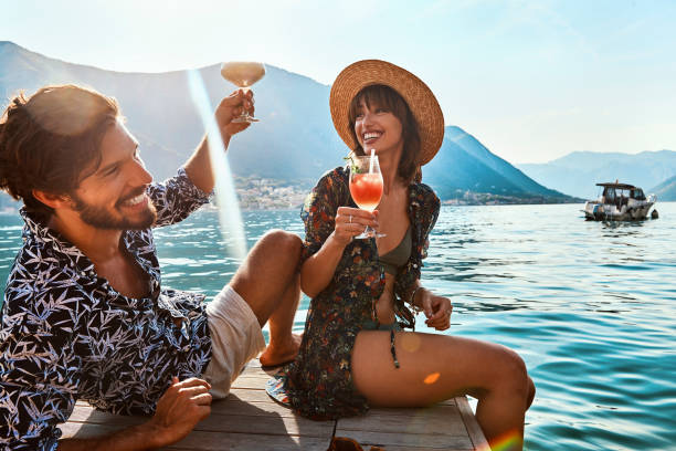海でカクテルを飲むハネムーン休暇の幸せなカップル - beach tropical climate holiday couple ストックフォトと画像