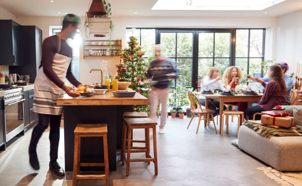 istock Group Of Friends At Home Preparing And Serving Christmas Dinner 1178295515