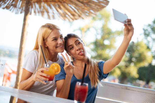 istock Two female friends taking Selfie in a bar while drinking cocktails 1178295915