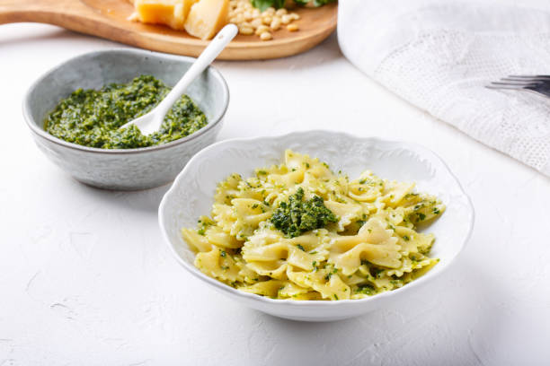 istock Farfalle pasta in  basil pesto sauce in white plate on white table. 1178296234