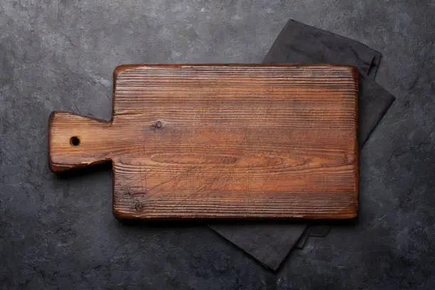 Cutting board over towel on stone kitchen table. Top view flat lay