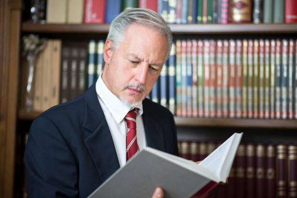 istock Businessman reading a book in his library 1178303360
