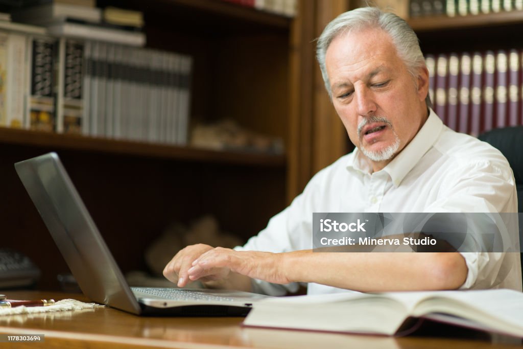 Guy Reading Computer Man Using His Laptop While Reading A Book Stock Photo - Download Image ...