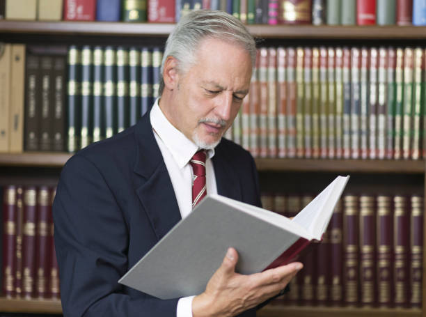 istock Businessman reading a book in a library 1178304294