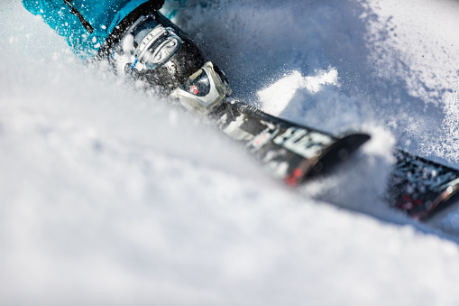 Close up of unrecognizable person skiing on snow. Copy space.