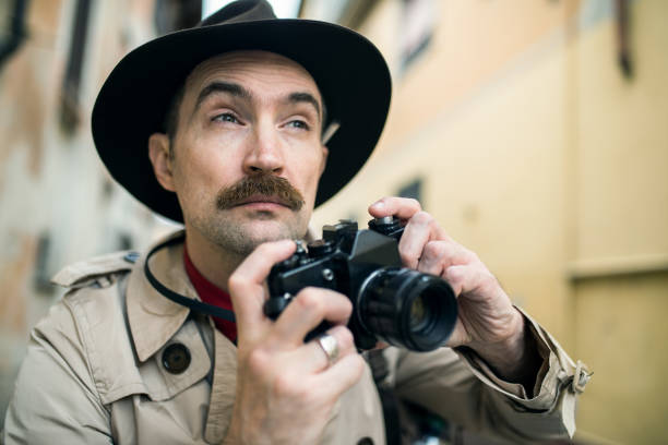 istock Man using vintage camera in a city street 1178309867