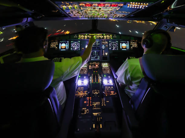 Night Flight with Pilots Center View Two Pilots flying actively an through the night. The view is from the center of the flight deck and motion blur from the outside as well as from the working pilots. throttle photos stock pictures, royalty-free photos & images