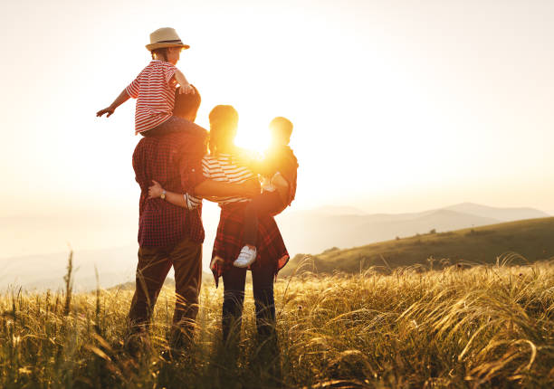 幸せな家族:日没の母、父、子供の息子と娘 - child dancing ethnic outdoors ストックフォトと画像