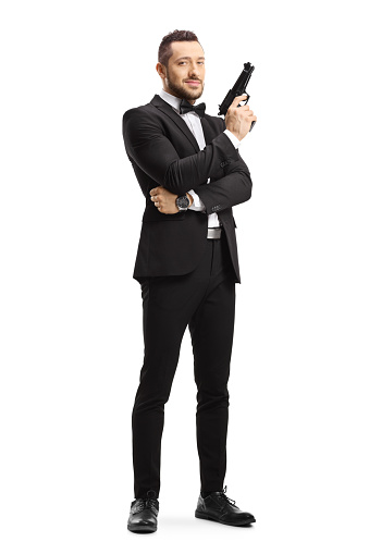 Full length portrait of a man in a suit holding a gun isolated on white background