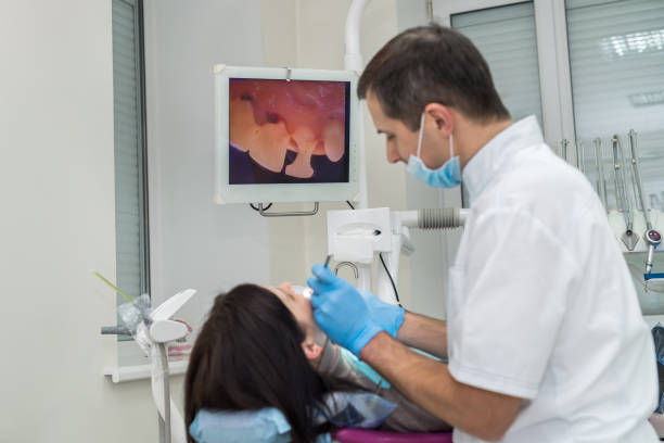 dentista que verific os dentes do paciente com a câmera na estomatologia - medical exam dental hygiene caucasian mask - fotografias e filmes do acervo