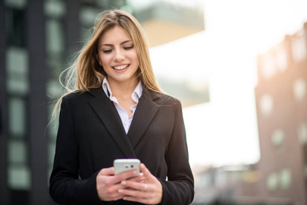 istock Smiling business woman using her mobile phone 1178317752