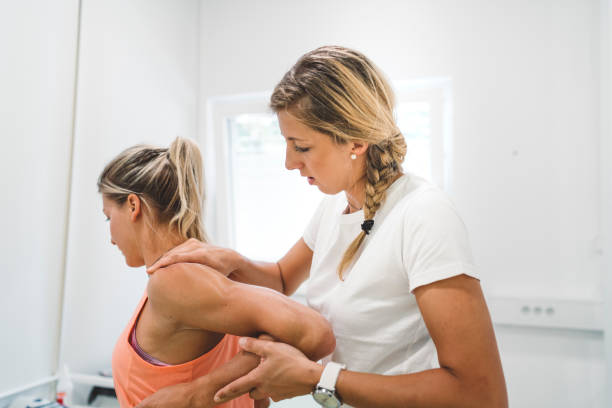 Physio massaging sore muscles on patient arm