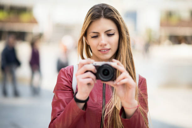 istock Smiling young woman holding a camera 1178318185