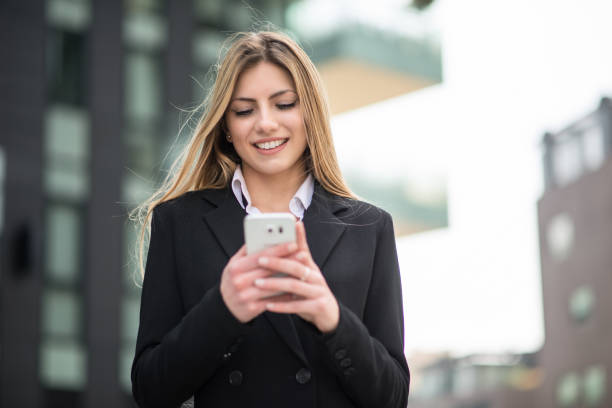 istock Smiling business woman using her mobile phone 1178318196