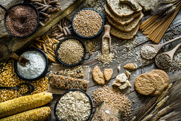 fibre diététique : grand groupe de nourriture de grains entiers projectile sur la table en bois rustique - whole wheat flour photos et images de collection