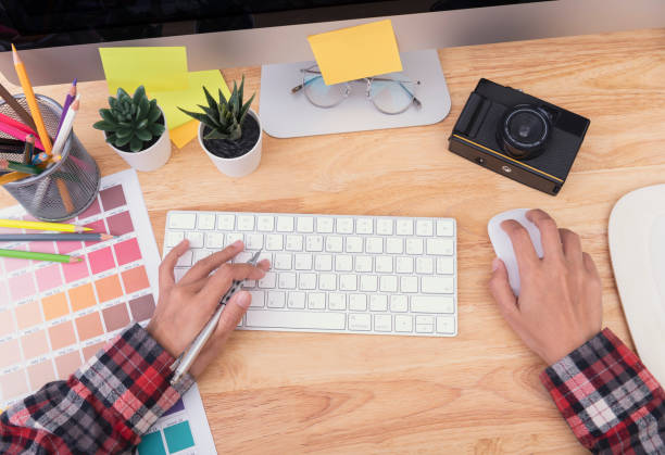 istock Graphic designer artist hands typing on a keyboard computer that is on a wooden desk with equipment for creative. 1178320370