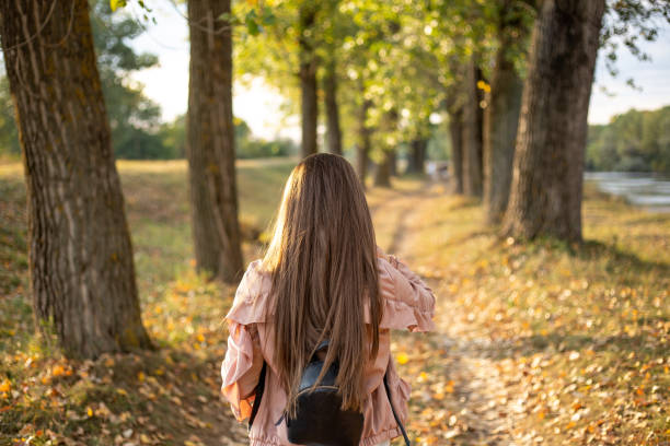 istock Brunette walking through the woods at sunset in autumn 1178320387