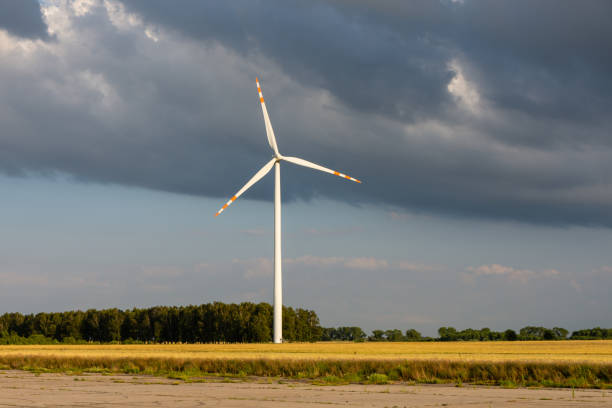 istock lonely windmill in a rape field. Dark clouds. Place for text 1178320796