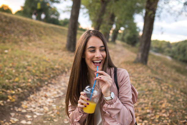 istock Brunette enjoying her break in the park while drinking orange juice 1178321449