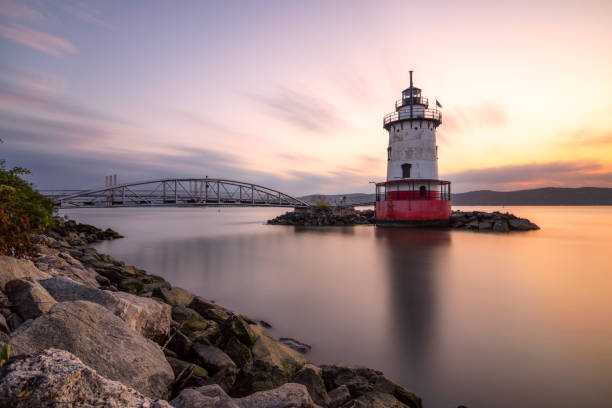 istock Caisson (sparkplug) style lighthouse under soft golden light with a bridge in the background. 1178322462