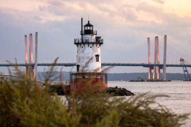 istock Caisson (sparkplug) style lighthouse under soft golden light with a bridge in the background. 1178322463
