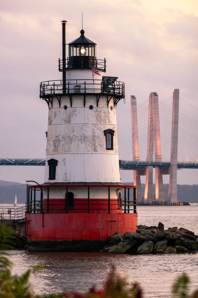 istock Caisson (sparkplug) style lighthouse under soft golden light with a bridge in the background. 1178322487