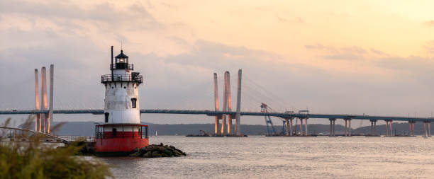 istock Panorama of a caisson (sparkplug) style lighthouse under soft golden light with a bridge in the background. 1178322490