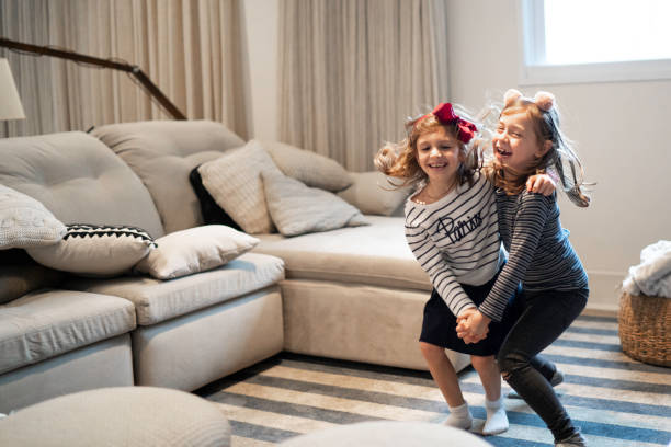 niñas bailando en la sala de estar - cousin fotografías e imágenes de stock