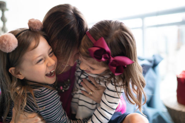 istock Mother and daughters embracing and having fun together at home 1178329237
