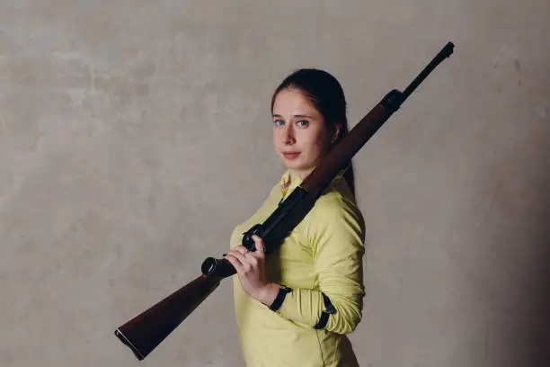 Young woman with rifle on shoulder