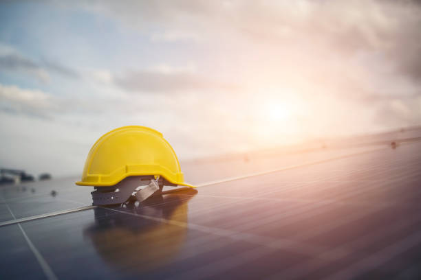 Yellow safety helmet on solar cell panel stock photo