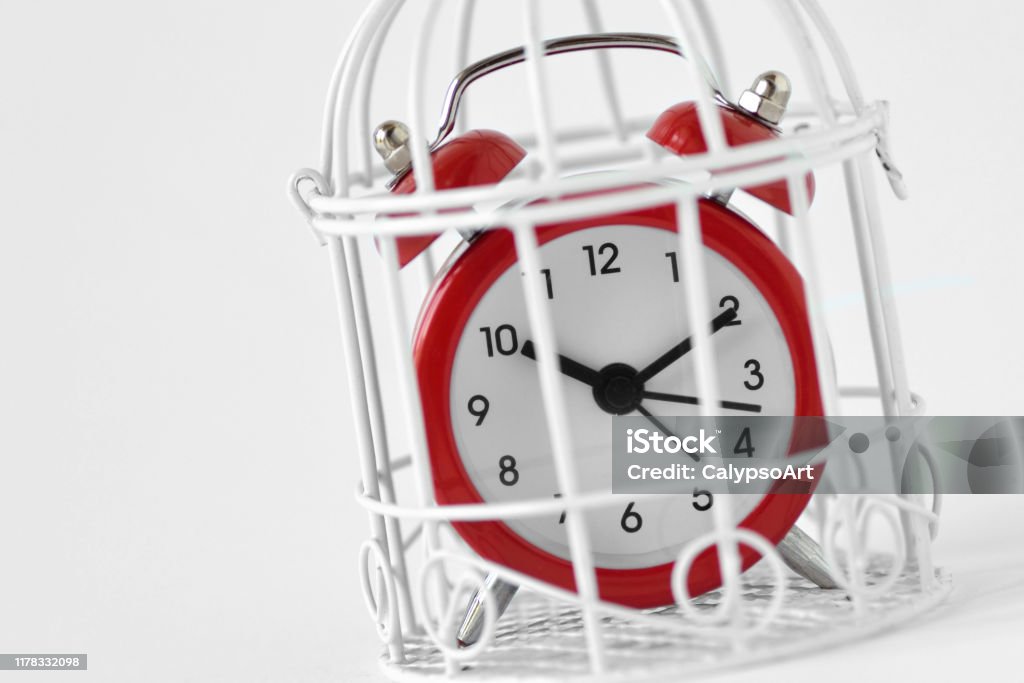 Close-up of red alarm clock in a cage - Concept of time limit Time Stock Photo