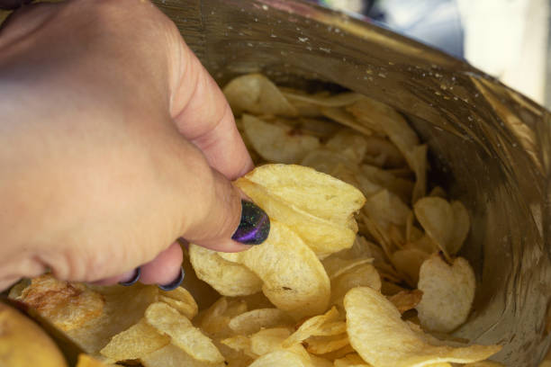 istock Woman hand picking potato chips in bag 1178333598