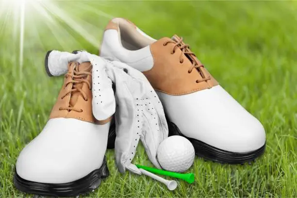 Pair of golfing shoes and a golf club