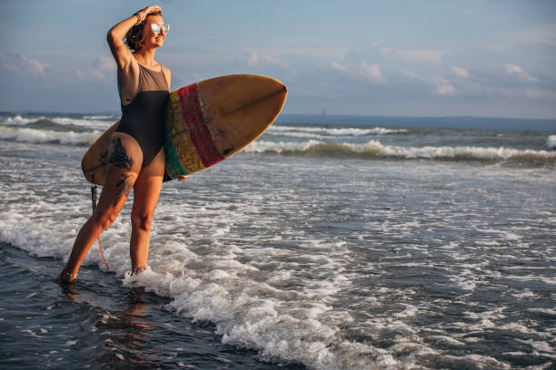 istock Woman carrying surfboard 1178338461