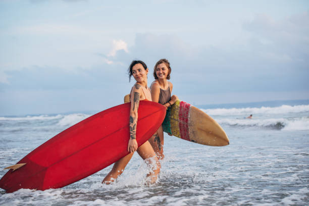 istock Woman surfers at the beach 1178339212